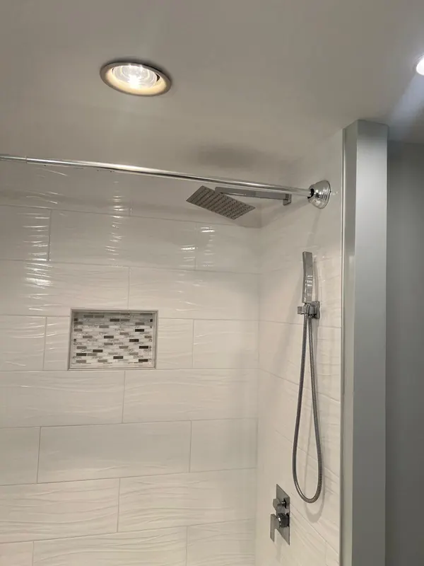 Finished tiled shower with a rain showerhead, hand shower and mosaic niche
