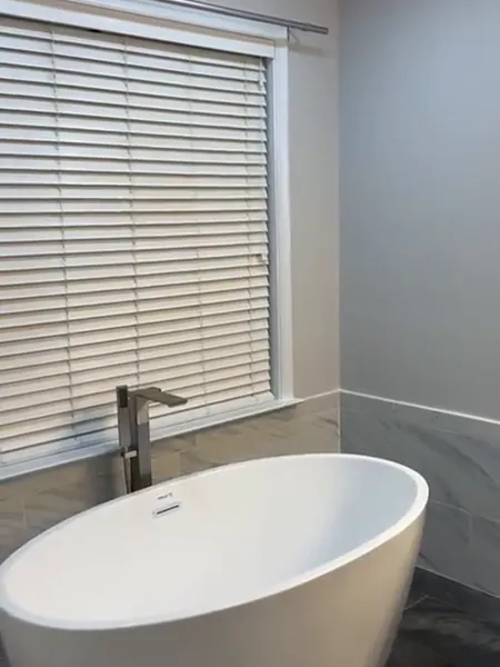 Walkthrough of a finished bathroom with a soaking tub, toilet and vanity