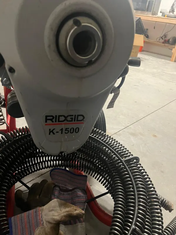 Close-up of a drain cleaning machine and its cable