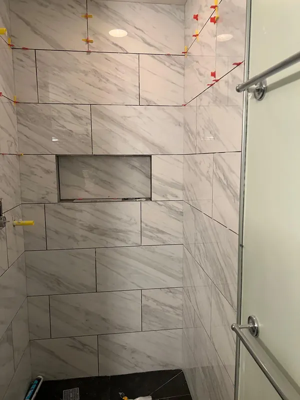 Tiled shower with a recessed niche, with tile spacers still in place